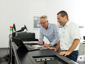 Zwei Männer stehen an der Produktionsdruckmaschine